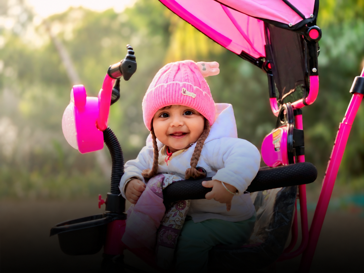 smiling toddler in pink stroller (1)